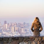 woman on rock platform viewing city
