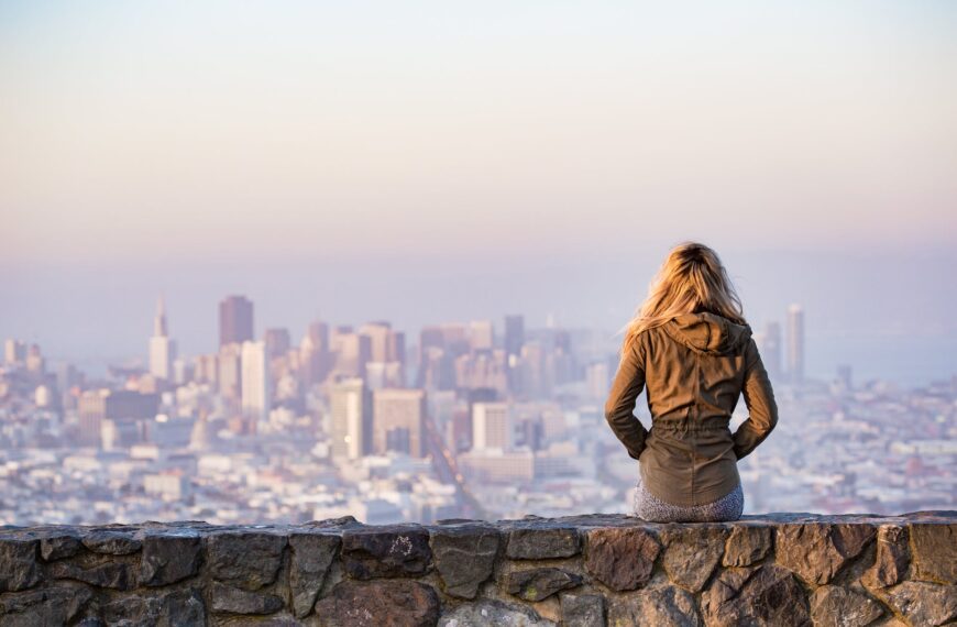 woman on rock platform viewing city