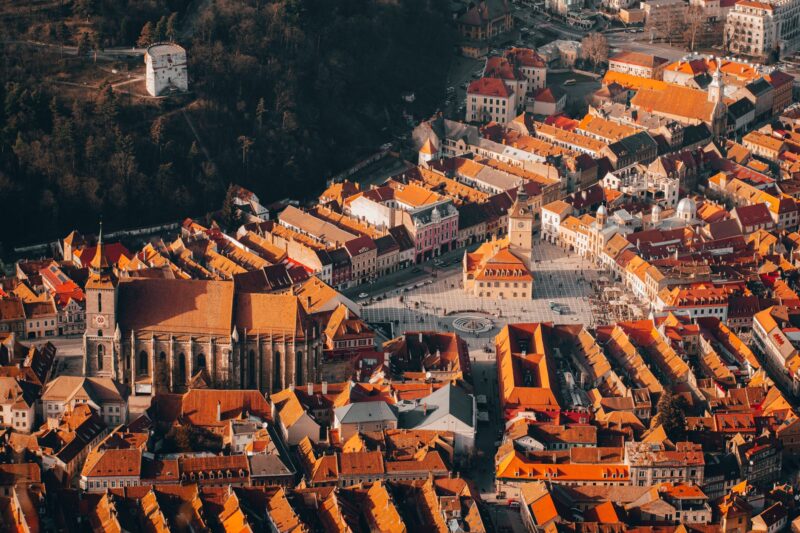 an aerial view of casa sfatului surrounded by city buildings in brasov romania