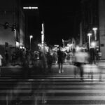 group of people crossing pedestrian lane in greyscale